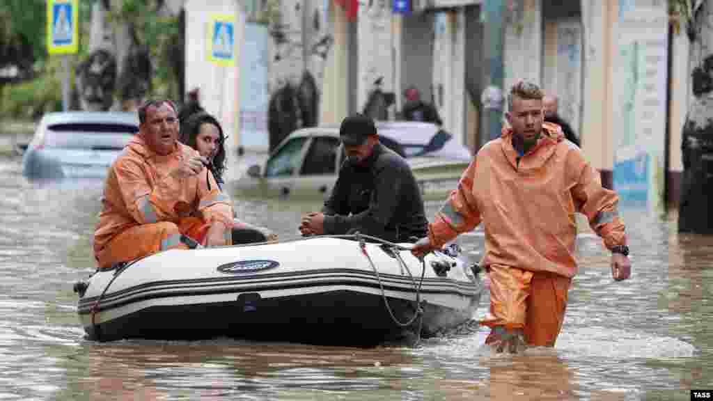 Russian Emergency Situations Ministry workers evacuate people by a boat from a Kerch neighborhood.