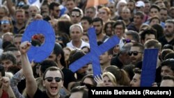 Демонстранти тримають листи зі словом «ні» (OXI) під час мітингу в Афінах. 3 липня 2015 року
