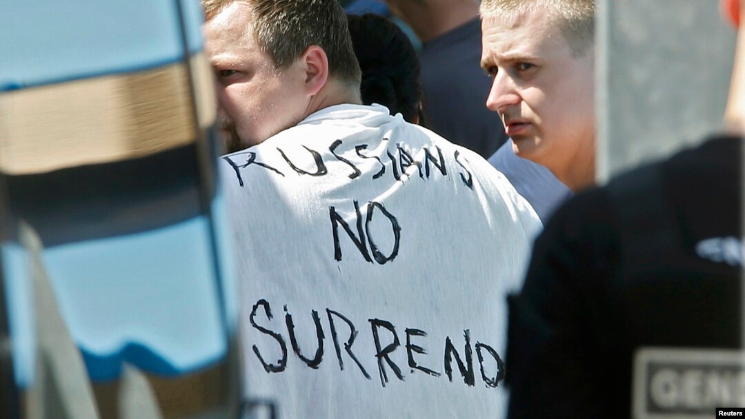 Russian soccer fans suspected of being involved in clashes, with one wearing a banner saying "Russia no surrender," are ushered off their bus after being stopped by gendarmes in Mandelieu near Cannes, France, on June 14.
