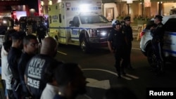 Policajci njujorške policije pored ambulantnog vozila u kojem je tijelo policajca ubijenog tijekom masovne pucnjave u Midtown Manhattanum 28. srpnja 2025.