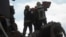 Echipele de salvare duc un copil găsit sub dărâmături în urma unui atac rusesc la Priluki, Ucraina, pe 7 octombrie. 