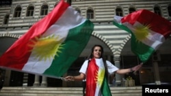 A woman waves Kurdish flags in Diyarbakir, Turkey, September 25, 2017. REUTERS