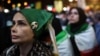 A woman wears a badge with a picture of the late Supreme Leader of Iran, Ayatollah Ali Khamenei, during a rally in Tehran