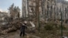 A woman cleans debris near a heavily damaged building, which was hit in a missile attack on the city of Izyum in eastern Ukraine on February 4. 