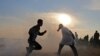 Palestinians run for cover from tear gas during clashes near the border between Israel and Khan Yunis in the southern Gaza Strip on November 9, 2018