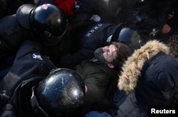 Një protestues duke u ndaluar nga policia në Omsk.