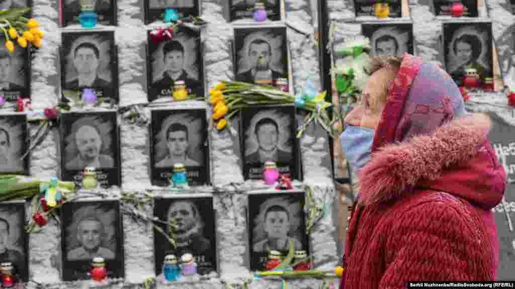 Egy nő áll a &quot;Mennyei százaknak&quot; elnevezett&nbsp;emlékmű előtt Kijevben február 18-án, hogy tiszteletét rója le a 104 ember emléke előtt, akiket a 2014-es kormányellenes tüntetéseken lőttek le. 