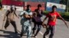 Supporters of Tahir-ul Qadri, Sufi cleric and leader of political party Pakistan Awami Tehreek (PAT), carry an injured fellow protester during the Revolution March in Islamabad on August 31, 2014.