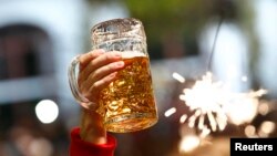 germany -- File photo of a beer being held aloft on the last day of the world's biggest beer festival, the 180th Oktoberfest, in Munich October 6, 2013. Beer sales rose in Germany, Europe's biggest producer, in the first half of the year thanks to a big j