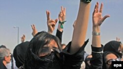 Iranian protesters shout slogans during an opposition rally at the cemetery 