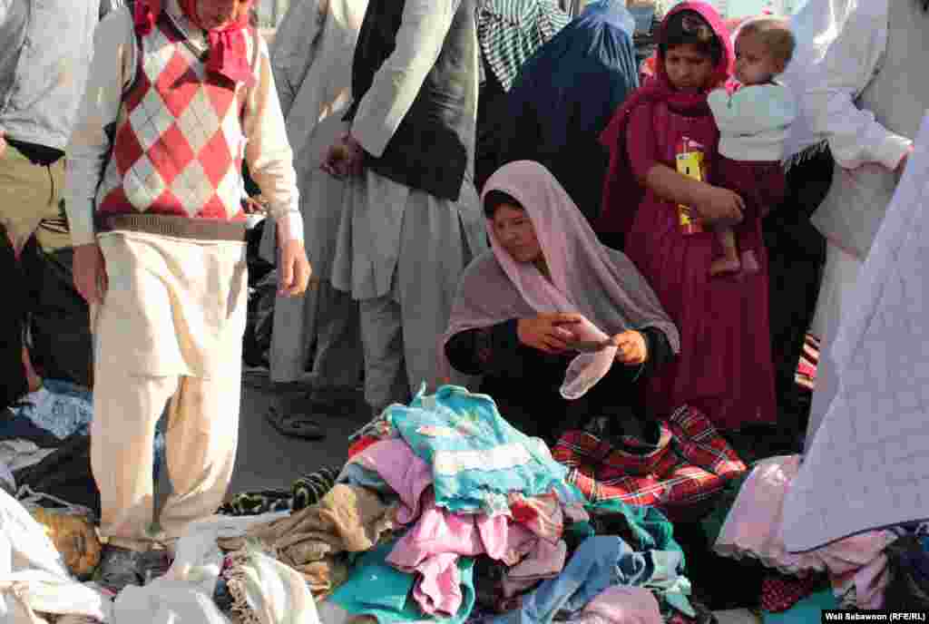 An Afghan woman sells used clothing in Kabul.