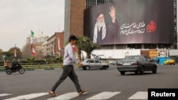 Ljudi hodaju pored bilborda pokojnog iranskog vrhovnog vođe ajatolaha Alija Hamneija na ulici, nakon što je ubijen u izraelskim i američkim napadima u subotu, u Teheranu, Iran, 2. marta 2026. godine.