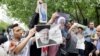 Iranian campaign activists distribute electoral posters of presidential candidates Rouhani and Raiesi after Friday prayers in Tehran, May 12, 2017