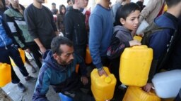 Palestinienii stau la coadă la apă în localitatea Khan Younis, din Fâșia Gaza, după ce Israelul a reluat ofensiva militară împotriva milițiilor Hamas. 4 decembrie 2023 (REUTERS/Ibraheem Abu Mustafa)

