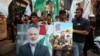 Palestinians carry pictures of late Hamas deputy leader Saleh al-Arouri and leader Ismail Haniyeh, who was assassinated in Iran, during a march to condemn Haniyeh's killing, at the Burj al-Barajneh Palestinian refugee camp in Beirut on July 31.