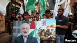 Palestinezët bartin fotografi të Ismail Haniyeh (majtas), liderit politik të Hamasit, i cili u vra në Iran, gjatë një marshi për ta dënuar vrasjen e tij, në kampin e refugjatëve palestinezë në Burj al-Barajneh, Bejrut, 31 korrik 2024.