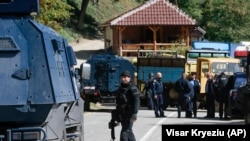Kosovski policajci osiguravaju područje na barikadama koje su lokalni Srbi postavili u blizini graničnog prijelaza Brnjak 24. rujna 2021. Srbi na Kosovu blokiraju granicu u znak protesta protiv odluke Prištine da počne uklanjati srpske tablice s automobila koji ulaze u zemlju.