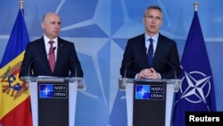 NATO Secretary-General Jens Stoltenberg (right) and Moldovan Prime Minister Pavel Filip give a press conference after their meeting at NATO headquarters in Brussels on March 30.