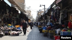 Oamenii fac cumpărături la o piață din Teheran. Locurile publice sunt în aceste zile aproape goale față de vremurile „normale” dinaintea ofensivei SUA-Israel.