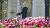 Kazakhstan. A woman in a protective mask is walking down the street. Almaty, April 25, 2020