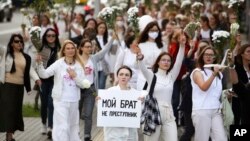 Žene predvode proteste u Minsku, dok jedna od njih nosi transparent "Moj brat nije prestupnik"