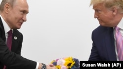 U.S. President Donald Trump (right) shakes hands with Russian President Vladimir Putin on the sidelines of a G20 summit in Japan on June 28