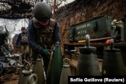 Військовослужбовець 13-ї бригади оперативного призначення «Хартія» Національної гвардії України перевіряє боєприпаси для самохідної гаубиці «Богдана», Харківська область, 3 грудня 2025 року