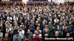 Iranian worshippers attend Friday Prayers in Tehran on January 5. Leading the prayers, hard-line cleric Ahmad Khatami said he backs the government's blocking of social media to disrupt the spread of information about the protests.