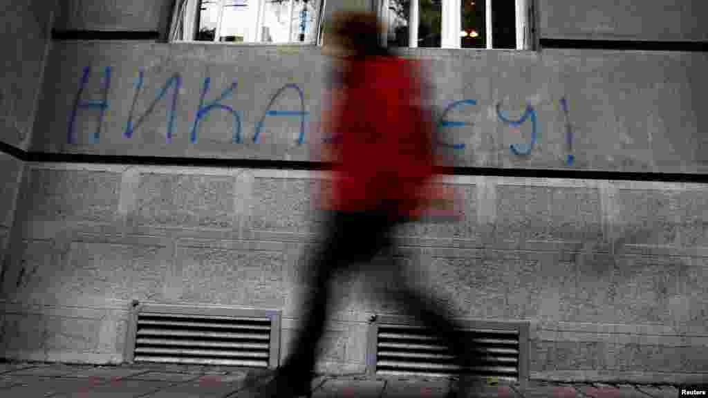 A man in downtown Belgrade walks past graffiti reading &quot;Never in the EU&quot; on December 8. (Photo for Reuters by Marko Djurica)