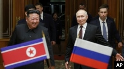 Președintele rus, Vladimir Putin, întâmpinat de liderul nord-coreean, Kim Jong Un, la Aeroportul din Phenian, Coreea de Nord, pe 19 iunie 2024. În timpul vizitei, Putin și Kim au semnat un tratat de parteneriat strategic între Rusia și Coreea de Nord.