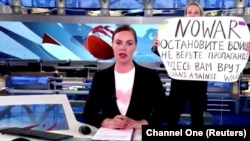 Marina Ovseannikova cu pancarta pe care scrie „NU RĂZBOIULUI. Opriți războiul. Nu credeți în propagandă. Aici vă mint”. Protestul a avut loc luni seară, în timpul buletinului de știri în direct, Moscova, 14 martie 2022. 