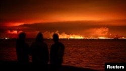 Turiști evacuați privesc incendiul de pădure din apropierea localității Lege-Cap-Ferret, din departamentul Gironde, Franța, în noaptea de joi spre vineri.