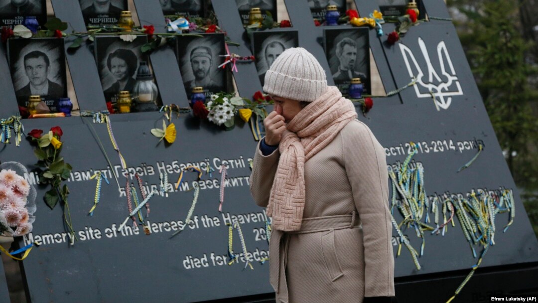 A woman pays respects at a memorial for people killed in clashes with security forces six years ago in Kyiv.