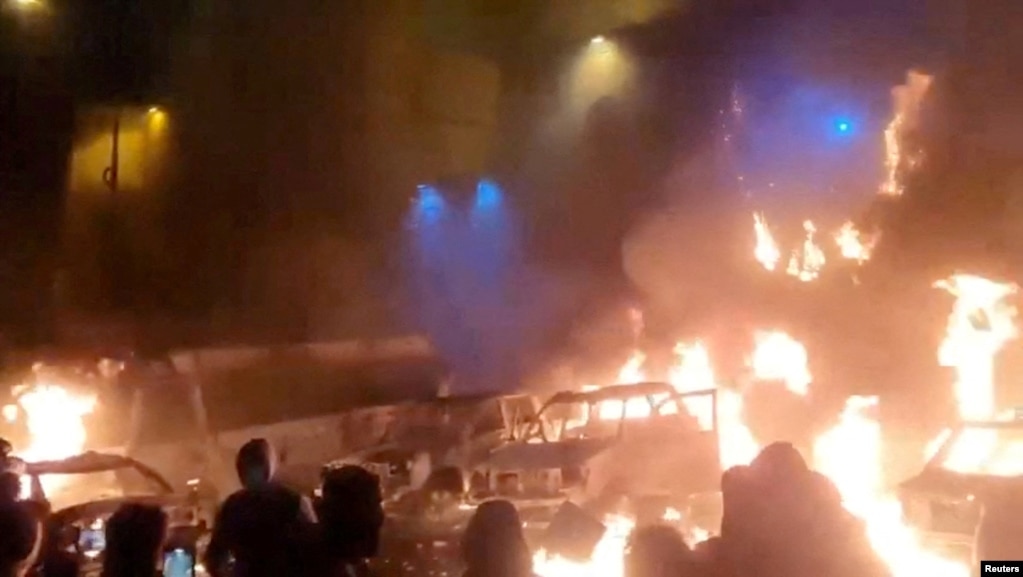 Protesters in Tehran gather as vehicles burn amid anti-government unrest in Iran.