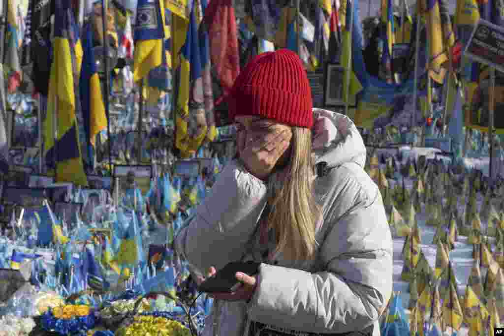 A Ukrainian woman cries at a memorial to her country's fallen soldiers on Kyiv's Independence Square on February 24. 