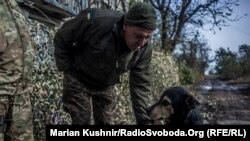 Солдат грає із собакою на передовій. Донбас, жовтень 2016 року