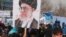 Afghans protesting allegations of Iranian abuse of Afghan refugees hold an image of Iranian Supreme Leader Ali Khamenei at a Kabul demonstration on January 13.