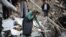 A woman walks among destroyed houses in the Iranian city of Varzaqan in Iran's northwestern province of East Azerbaijan on August 12.
