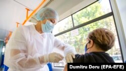 Një punonjëse shëndetësor administron një dozë vaksine kundër COVID-19 te një grua në Kishinau, Moldavi, 06 Shtator 2021. 