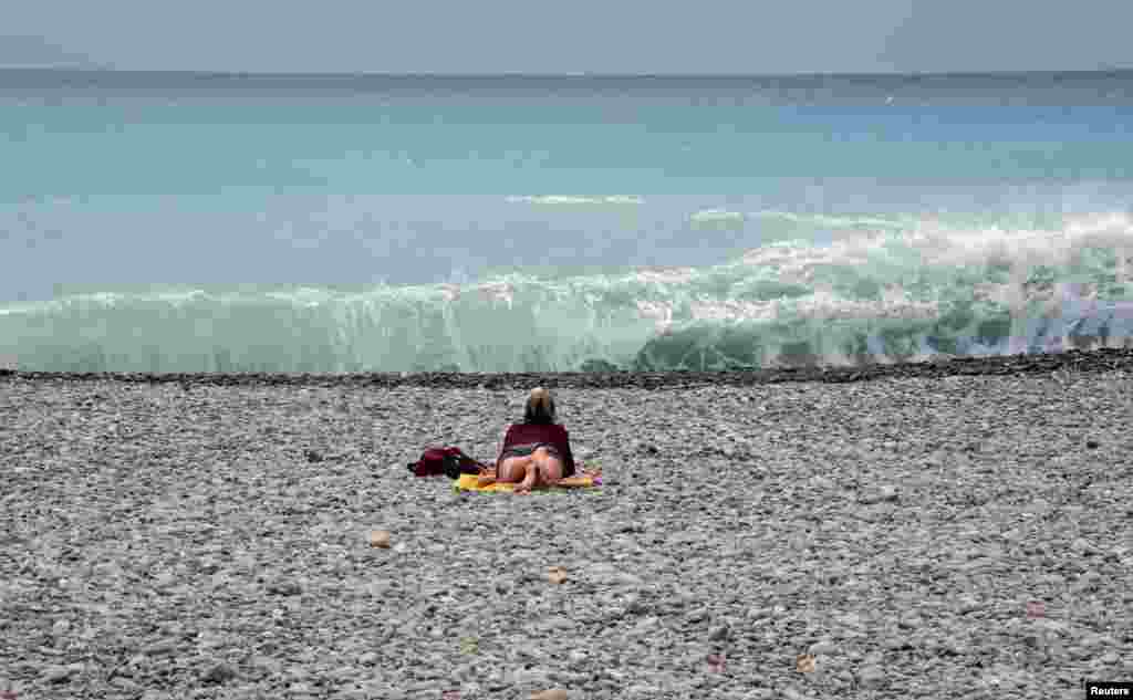 Fransanın dəniz sahillərində küləkli gündə istirahət edən qadın