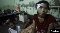 A victim of recent violence in Burma rests in hospital after being treated for a gunshot wound. 