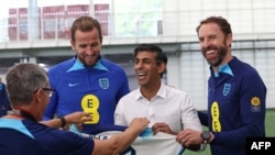Kryeministri i Britanisë së Madhe, Rishi Sunak (në mes) sulmuesi i Anglisë, Harry Kane (majtas), dhe trajneri i Anglisë, Gareth Southgate, në qendrën stërvitore të Kombëtares së Anglisë, 10 tetor 2023.
