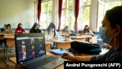 Egy bukaresti tanár számítógépen beszél a diákjaival 2020. szeptember 18-án. A szigorítást a koronavírus-járvány miatt vezették be.