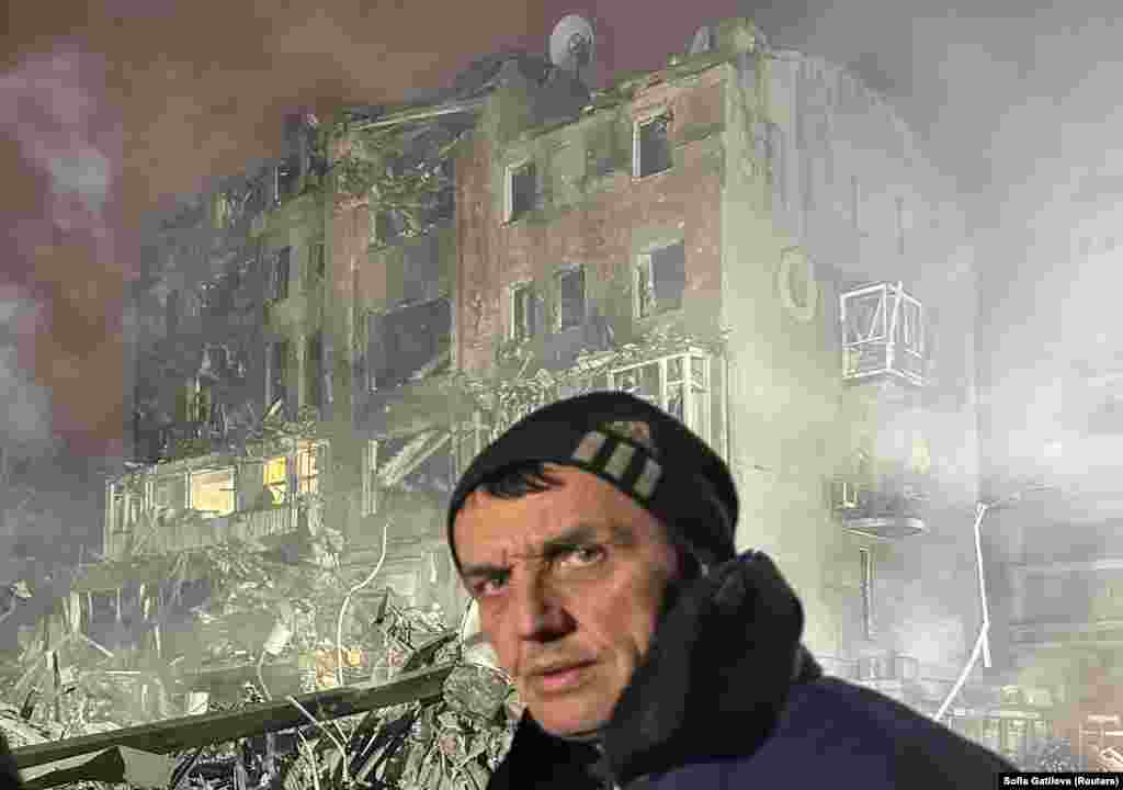 Чоловік стоїть біля багатоквартирного будинку, пошкодженого внаслідок російського авіаудару. Харків, 2 січня 2026 року.Російські війська вдень 2 січня завдали удару по Харкову, атакувавши місто ракетами «Іскандер». Внаслідок удару зруйнована пʼятиповерхова будівля, а також частина під’їзду чотириповерхового багатоквартирного будинку з торговельним центром і супермаркетом на першому поверсі