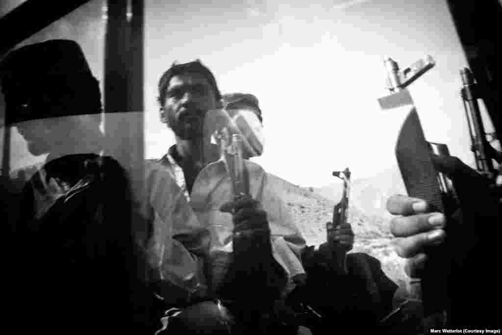 Insurgent fighters belonging to the Baloch nationalist movement sit in the back of a pick-up truck near the town of Dera Bugti.