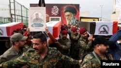 Members of the Popular Mobilization Forces carry the remains of fighters killed in suspected US air strikes in Baghdad in April. 