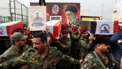 Members of the Popular Mobilisation Forces -- an umbrella organization of mostly Shi'a, Iran-backed armed groups that is part of the Iraqi Army -- carry the remains of fighters killed in air strikes, in Baghdad on April 2.