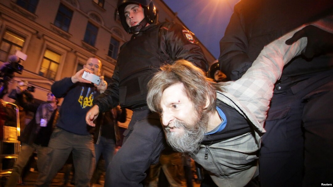 Police officers detain a supporter of Russian opposition leader Aleksei Navalny during a rally in St. Petersburg on October 7. Police detained at least 66 people.