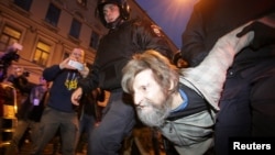 Police officers detain a supporter of Russian opposition leader Aleksei Navalny during a rally in St. Petersburg on October 7. Police detained at least 66 people.