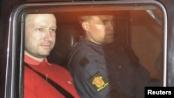Suspect Anders Behring Breivik (left), accused of a killing spree and bomb attack in Norway, sits in the rear of a vehicle as he is transported from a courthouse in Oslo on July 25.